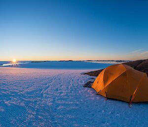 Tent on the snow with sunset