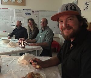 Four expeditioners eating dinner at table