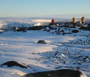 Three expeditioners and glacier in background