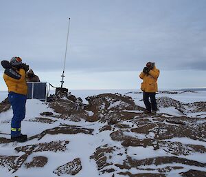 Three expeditioners inspecting the repeater installation