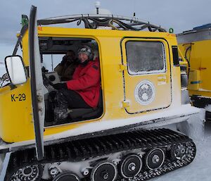 Expeditioner in driver’s seat of yellow Hägglunds vehicle