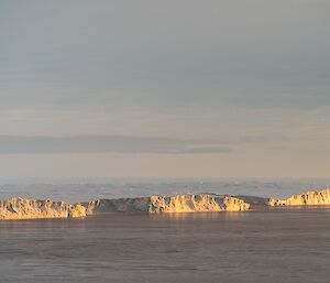 Distant ice cliffs reflecting the sunset