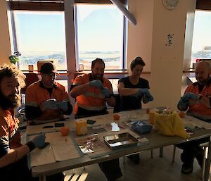 Expeditioners sitting around table with medical equipment laid out