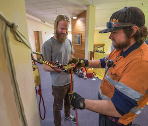 Two expeditioners practice tying knots