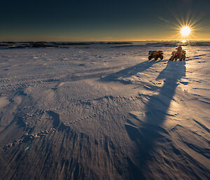 Quad bike on snow with sun in background