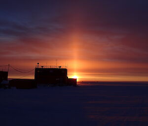 Beam of light shooting up from the sun into the sky