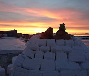Adam and Clint building an igloo with sunset