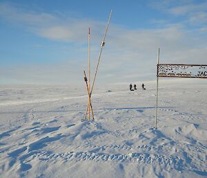 Hiker near sign and 3 other expeditioners in the background