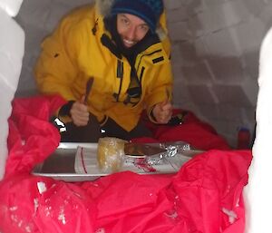 Expediitioner in igloo with breakfast on a tray