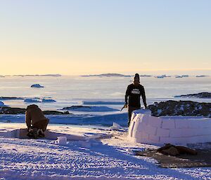 Adam and Clint building an igloo with hview of sea in background