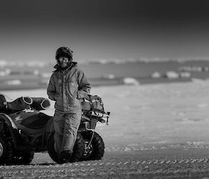 Adam leaning against a quad bike wearing helmet