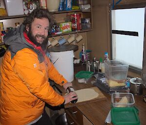 Shaun prepares a Pizza base on a bench