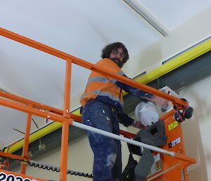 Chris on an elevated work platform painting