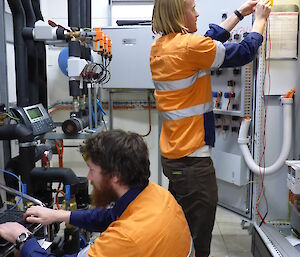 Two expediioners in high viz doing electrical work