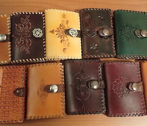 ten leather wallets on a table
