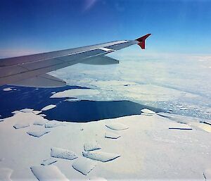 View of sea ice from air and aircraft wing in shot