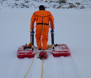 Expeditioner in orange suit using rescue alive