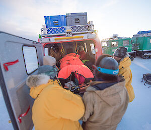 Expeditioners loading a stretcher into a Hägg.