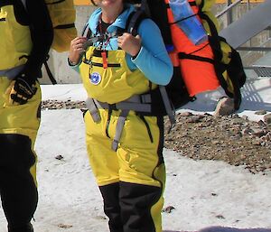 Ash wearing her survival pack in yellow overpants