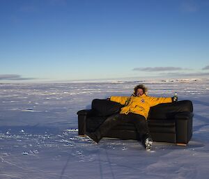 James in yellow jacket on a couch on ice.