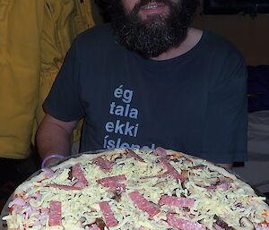 An expeditioner holding a pizza