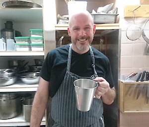 Andrew the chef holding a jug in the kitchen.