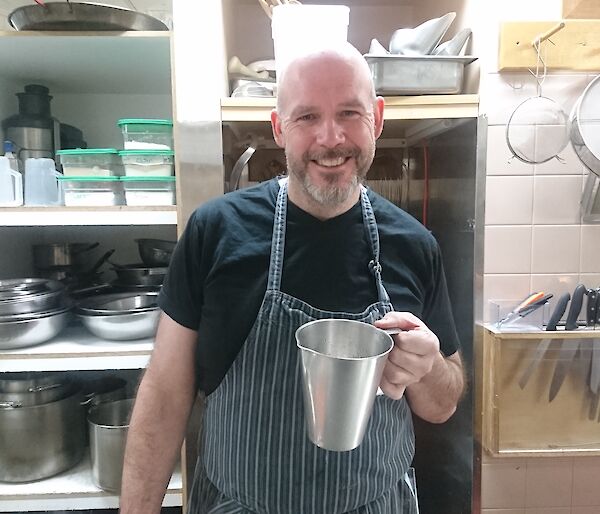 Andrew the chef holding a jug in the kitchen.