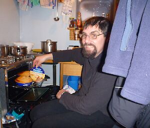 Scottish taking a Fray Bentos pie from the oven.