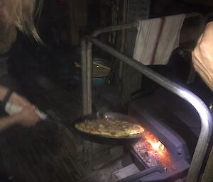 Pizza being taken out of the wood fired oven.