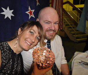 Jac and Brendan sitting together with the Australian flag behind them.