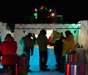 Expeditioners in an outdoor ice bar dancing.