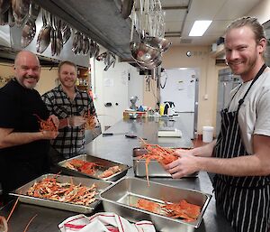 Chef and two expeditiones shelling lobsters.