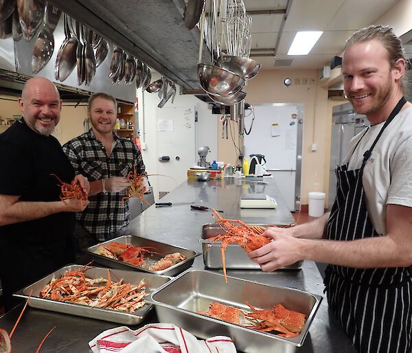 Chef and two expeditiones shelling lobsters.