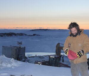 Ducky with sea ice in background looking at his red beanie