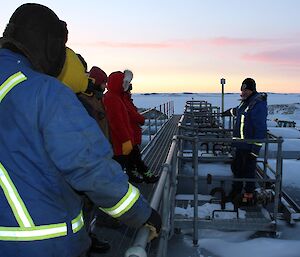 Expeditioners listening to Mick atop of the fuel farm.
