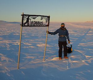 Mark at Robbos Hut sign with sled