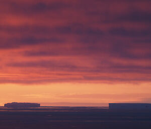 Pastel colours in clouds and icebergs on the sea