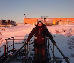 Brendan standing on upper fuel farm with workshop at rear