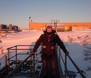 Brendan standing on upper fuel farm with workshop at rear