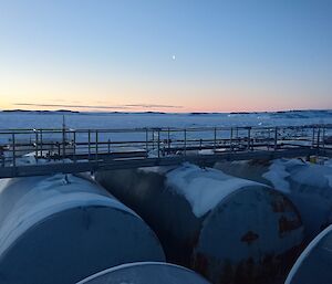 Moon rising behind fuel tanks