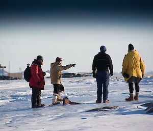 Four expeditioners, one pointing.