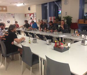 Expeditioners sitting in the mess around the table.