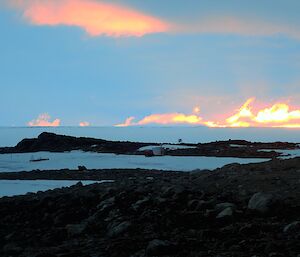 The sun in clouds on horizon.