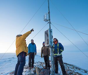 Expeditiones looking at an automated weather station.