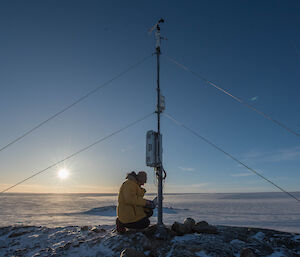 An expeditioner working on the automated weather station.