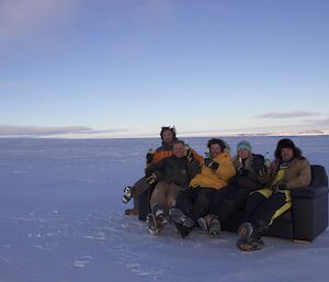 Expeditioners on a couch out on the ice.