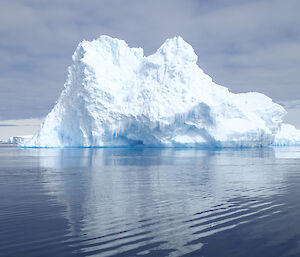 An iceberg with water in front of it.