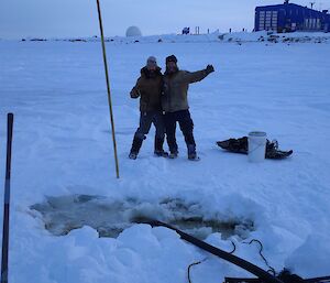 Two men standing out in the snow.