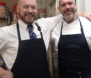 Brendan and Andrew the chef standing with their aprons on ready for midwinters feast.