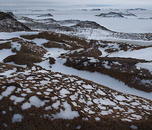 View over rocks to frozen sea.